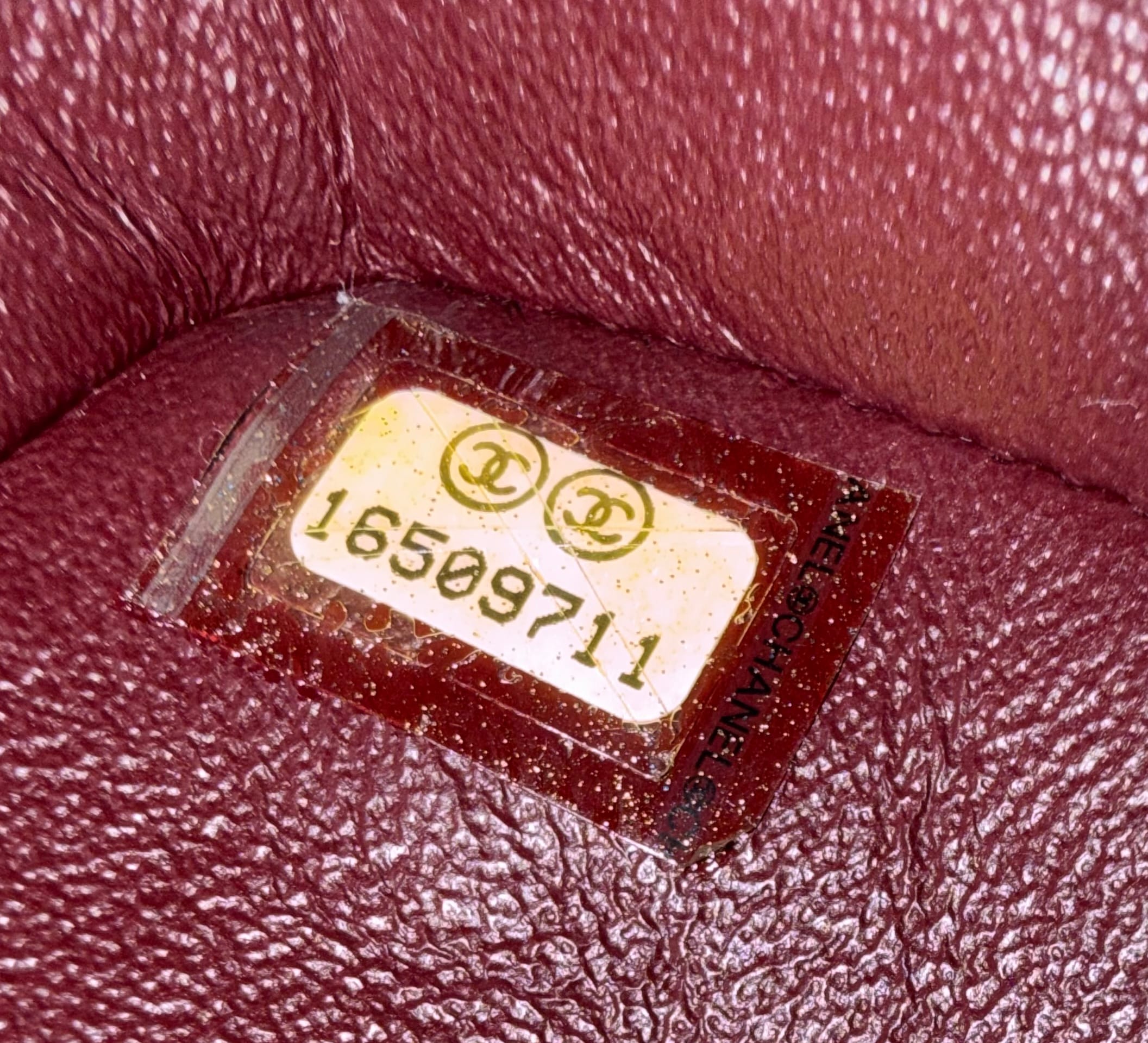 Authentic Chanel date code sticker from the 16 series (2012–2013) showing serial number 16509711 inside a Chanel bag.