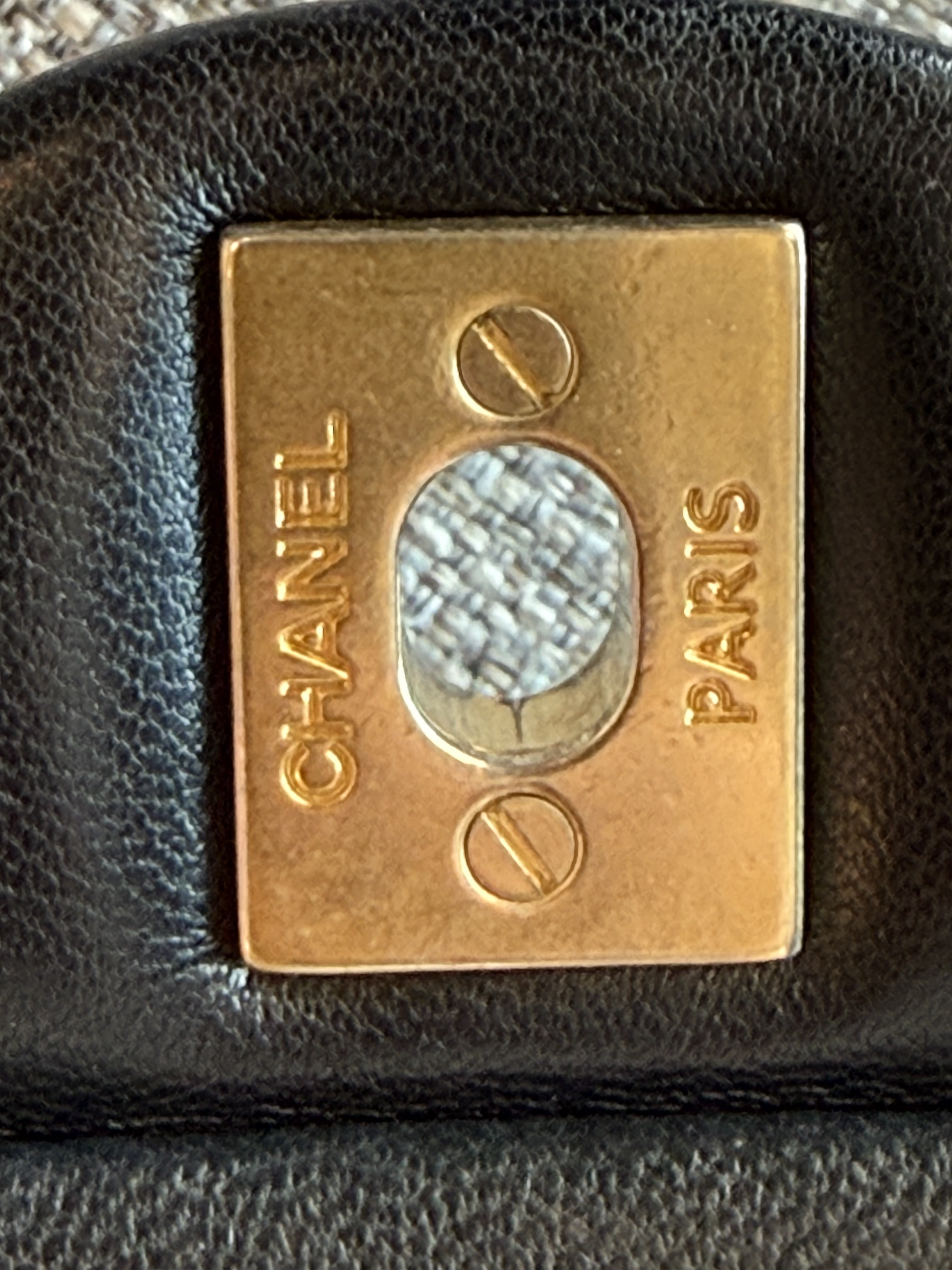 Chanel back plate close-up with flathead screws and engraved Chanel Paris stamp