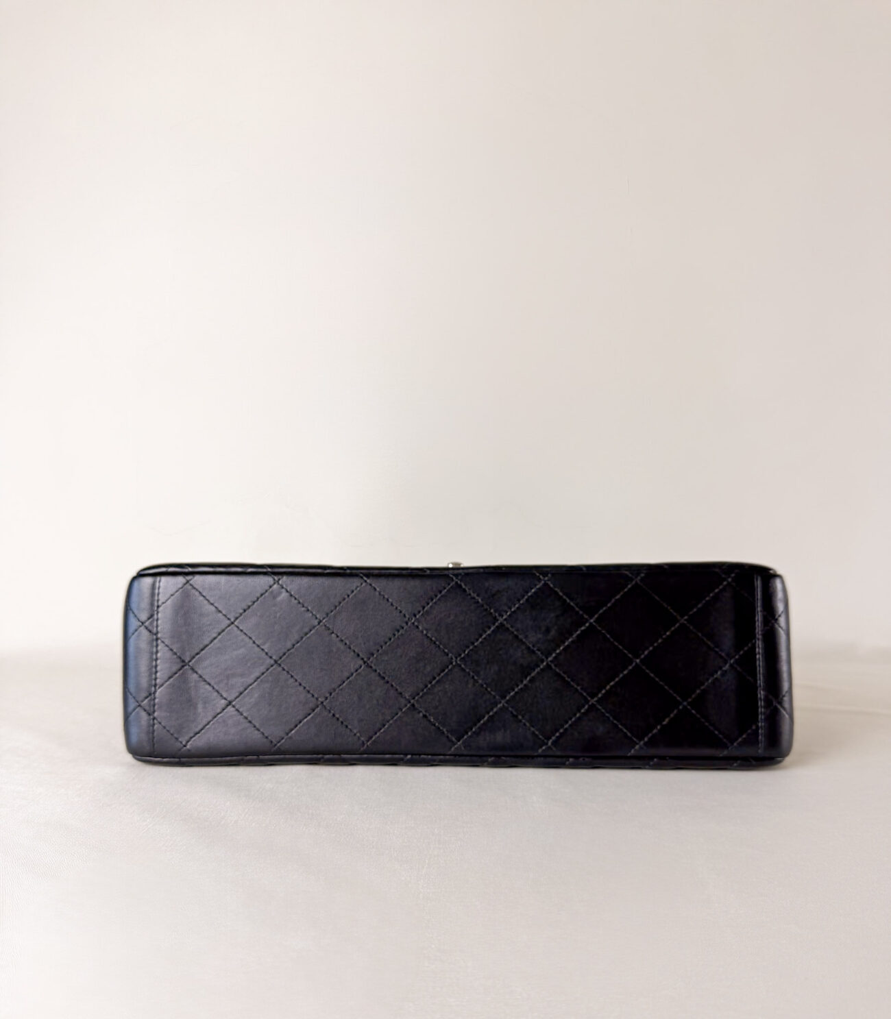Bottom view of Chanel Classic Flap Maxi Jumbo Double Flap bag in black lambskin with palladium hardware