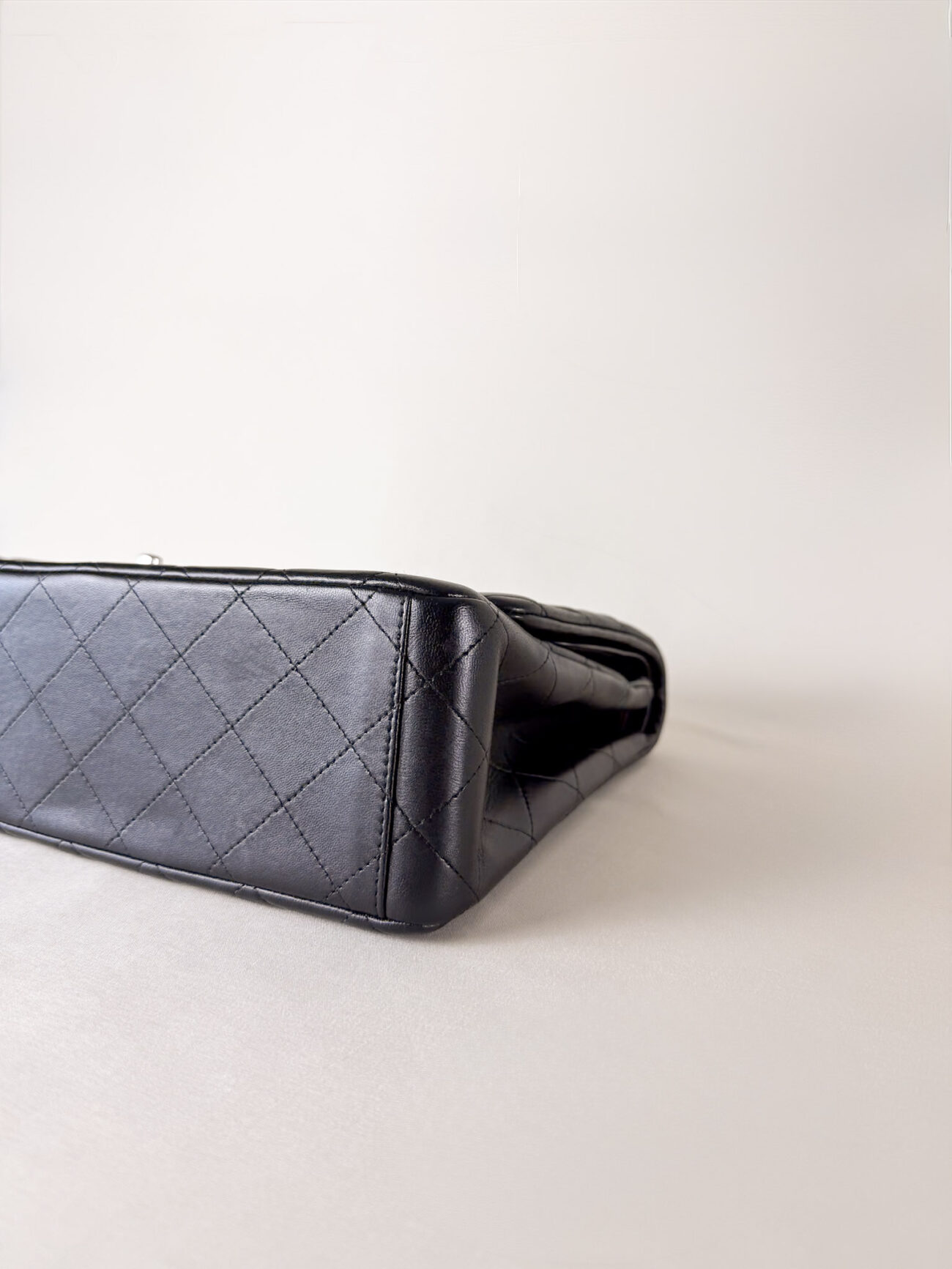 Right corner detail of Chanel Classic Flap Maxi Jumbo Double Flap bag in black lambskin