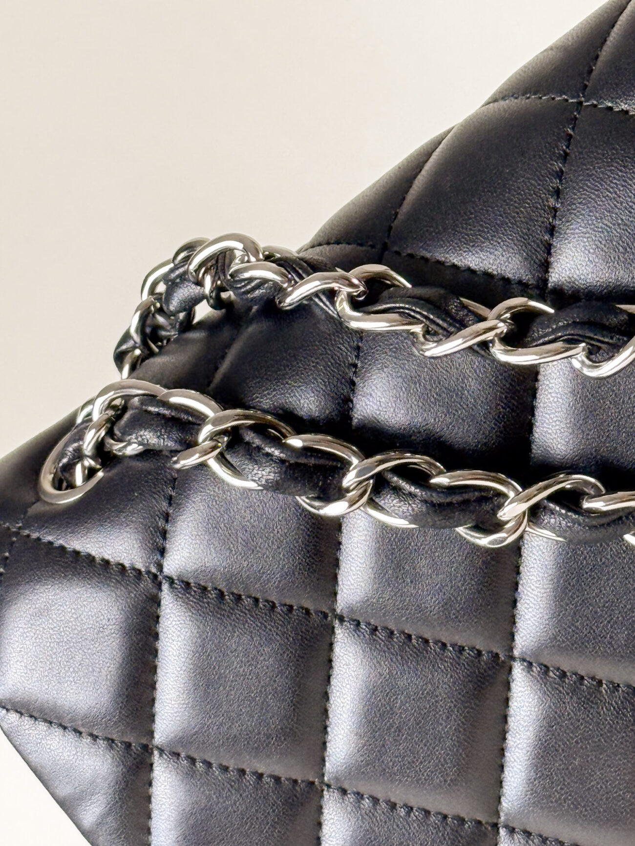 Chain and quilting detail of Chanel Classic Flap Maxi Jumbo Double Flap bag in black lambskin with palladium hardware
