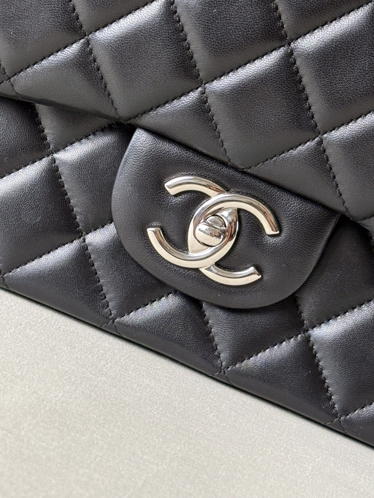 CC turn-lock hardware detail of Chanel Classic Flap Maxi Jumbo Double Flap bag with palladium hardware