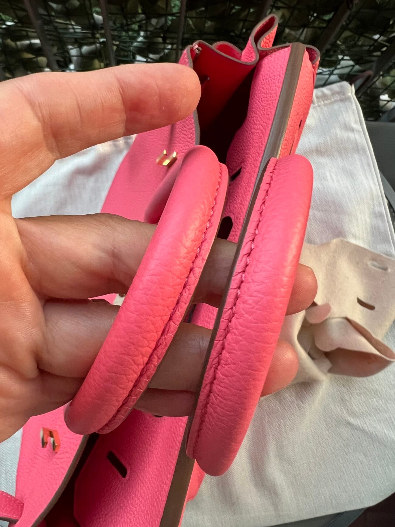 Close-up of the two rolled leather handles of Hermès Birkin 35 Rose Azalée, showing pink grained leather and detailed stitching