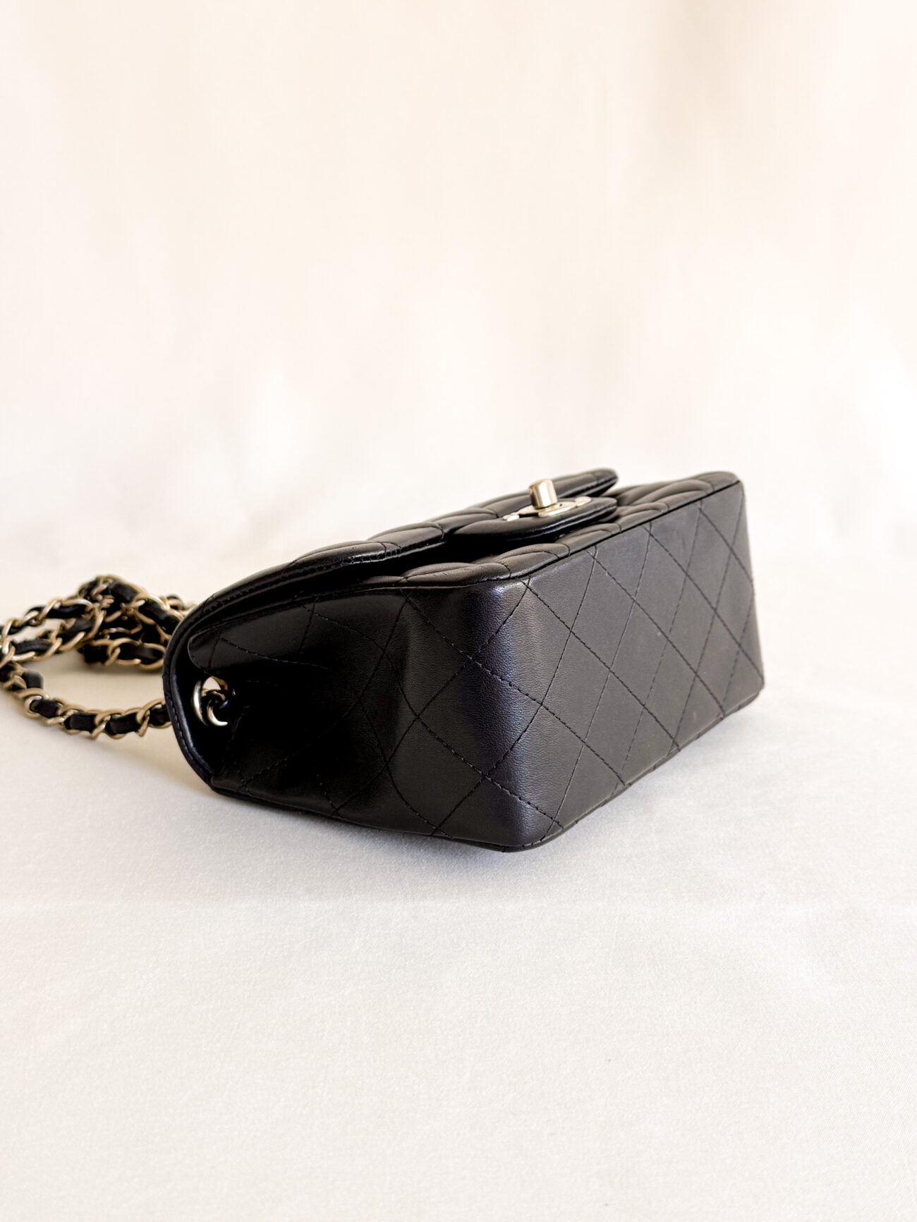 Chanel classic flap mini square black leather champagne hardware back angled view