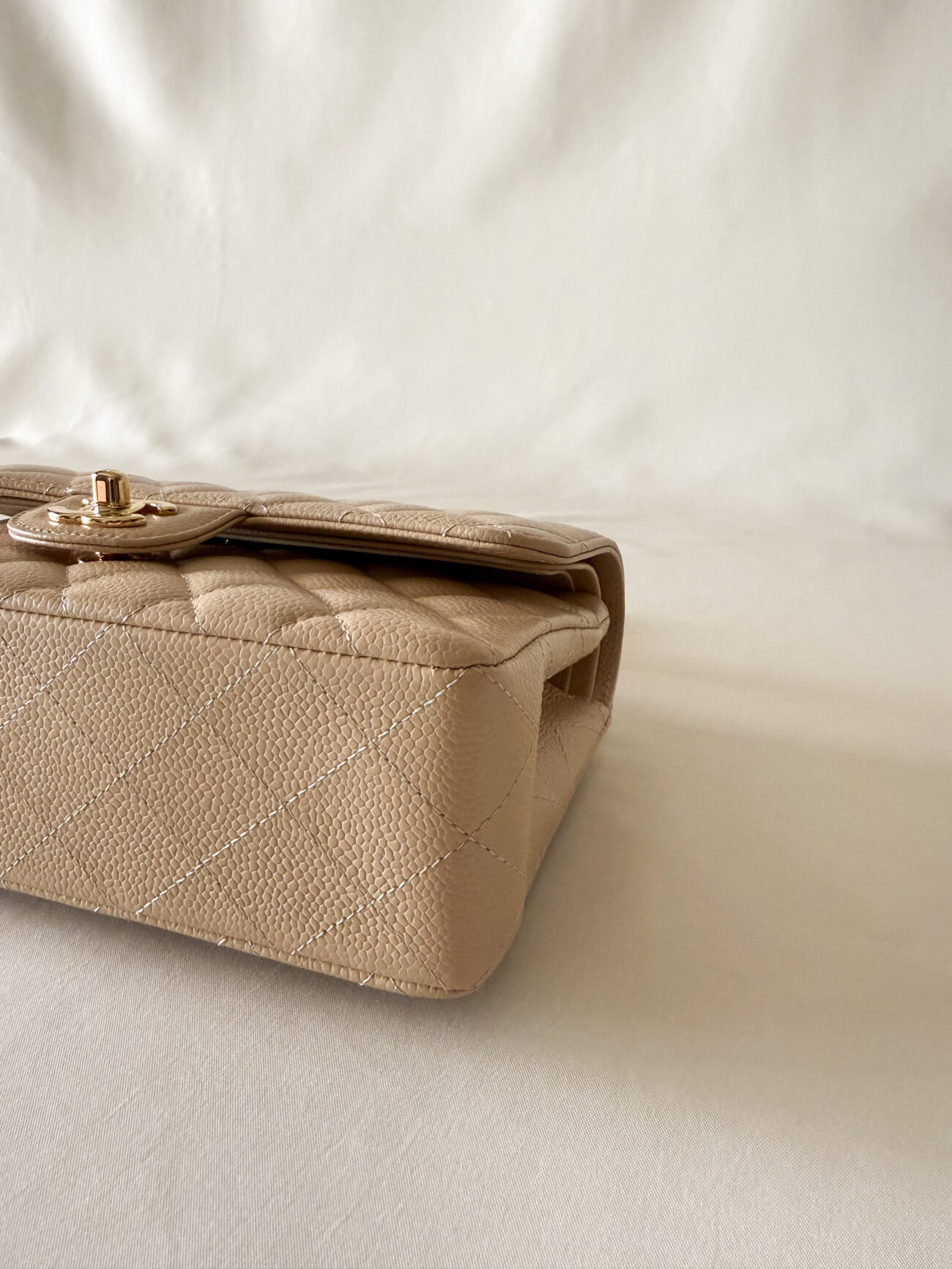 Chanel classic flap small beige caviar side view showing structured base and clean corner