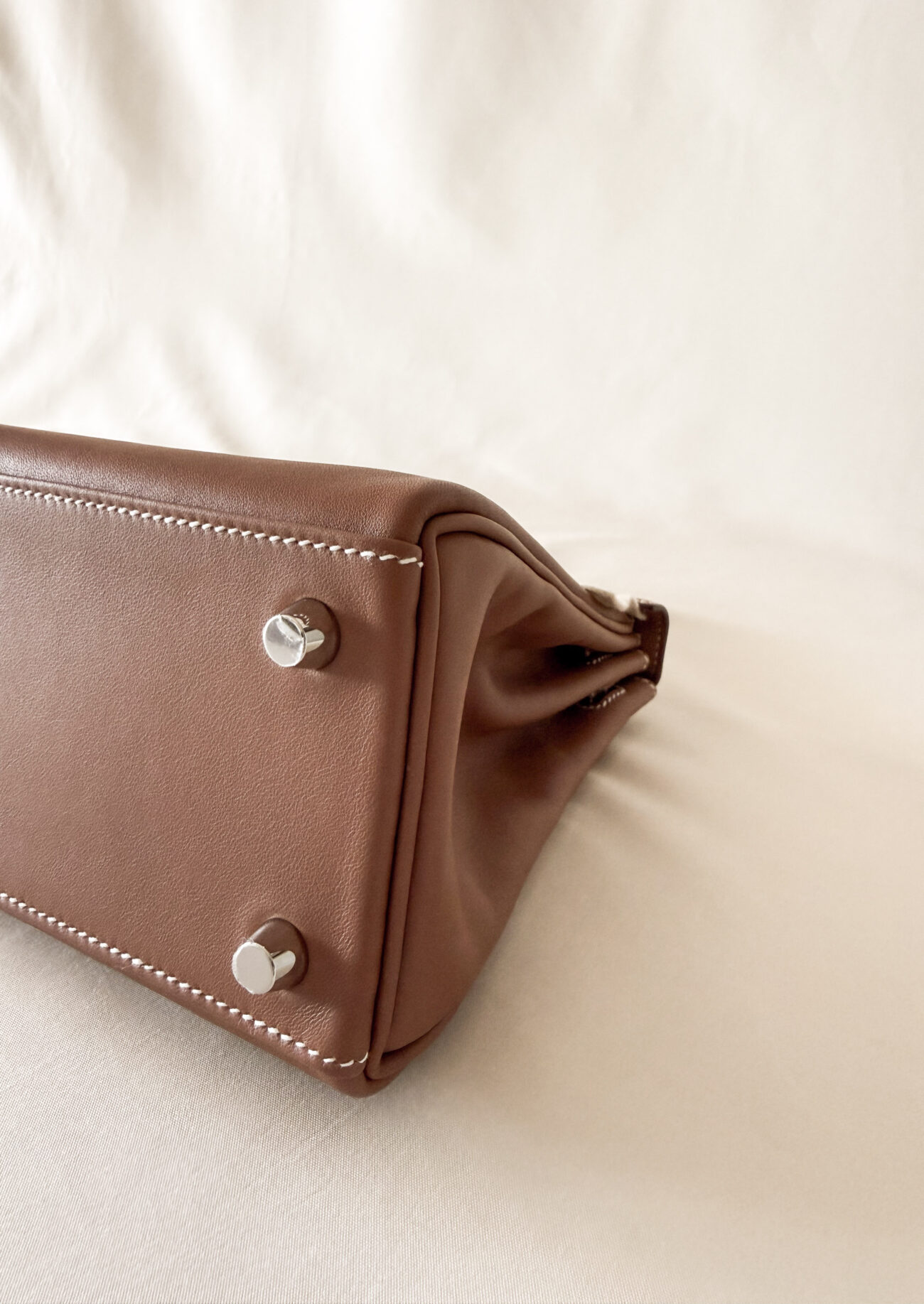 Hermès Kelly 25 Gold swift with palladium hardware angled bottom with feet view
