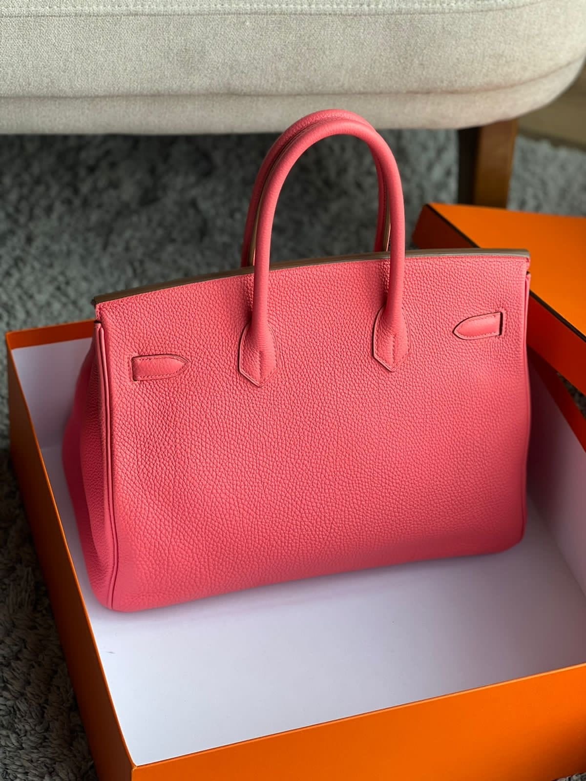 Back view of Hermès Birkin 35 Rose Azalée pink leather handbag showing its structured silhouette, double handles and grained leather texture.