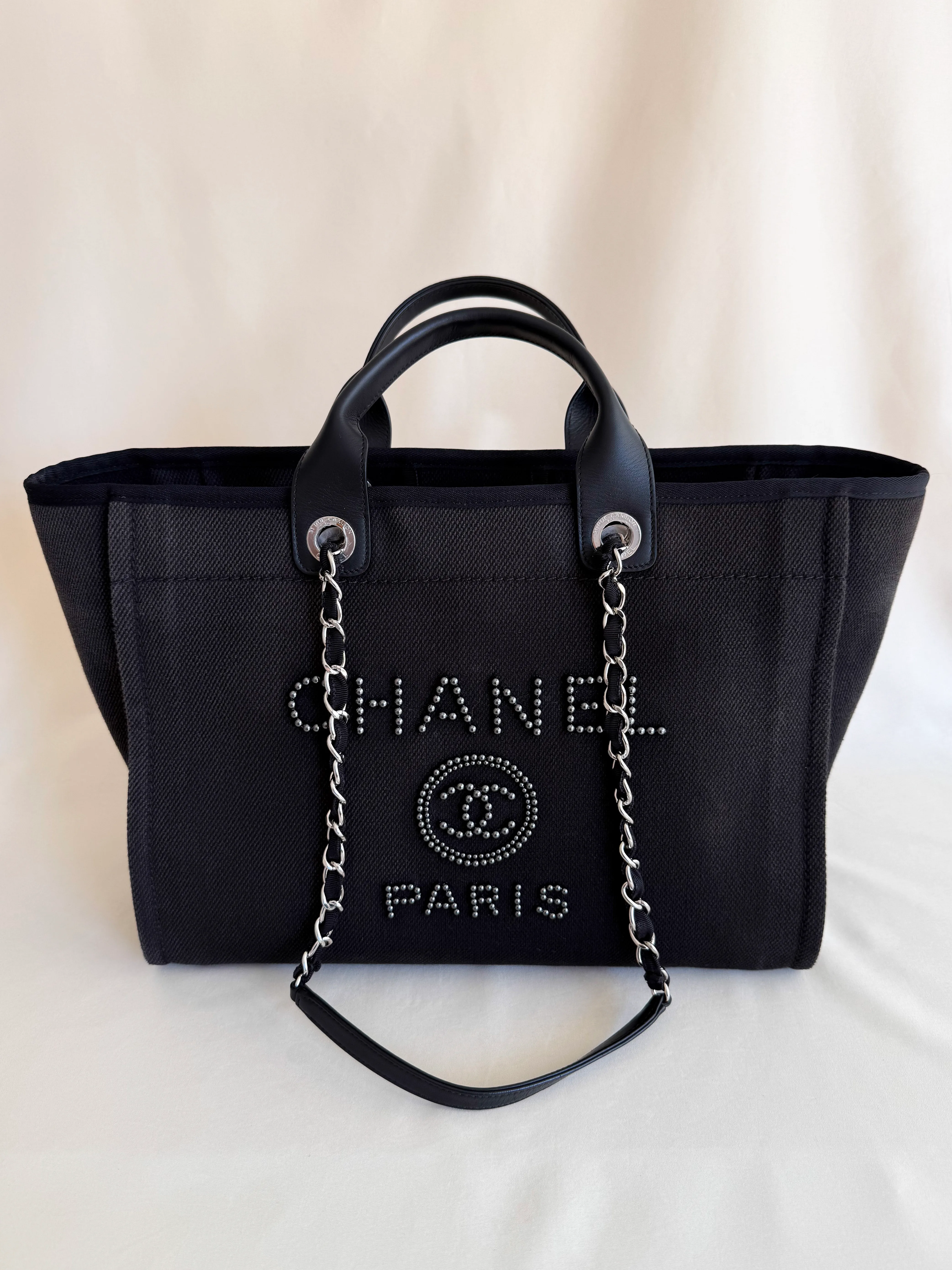 Chanel Deauville Tote nera in canvas con logo CHANEL PARIS ricamato con perle nere, manici in pelle e tracolla a catena