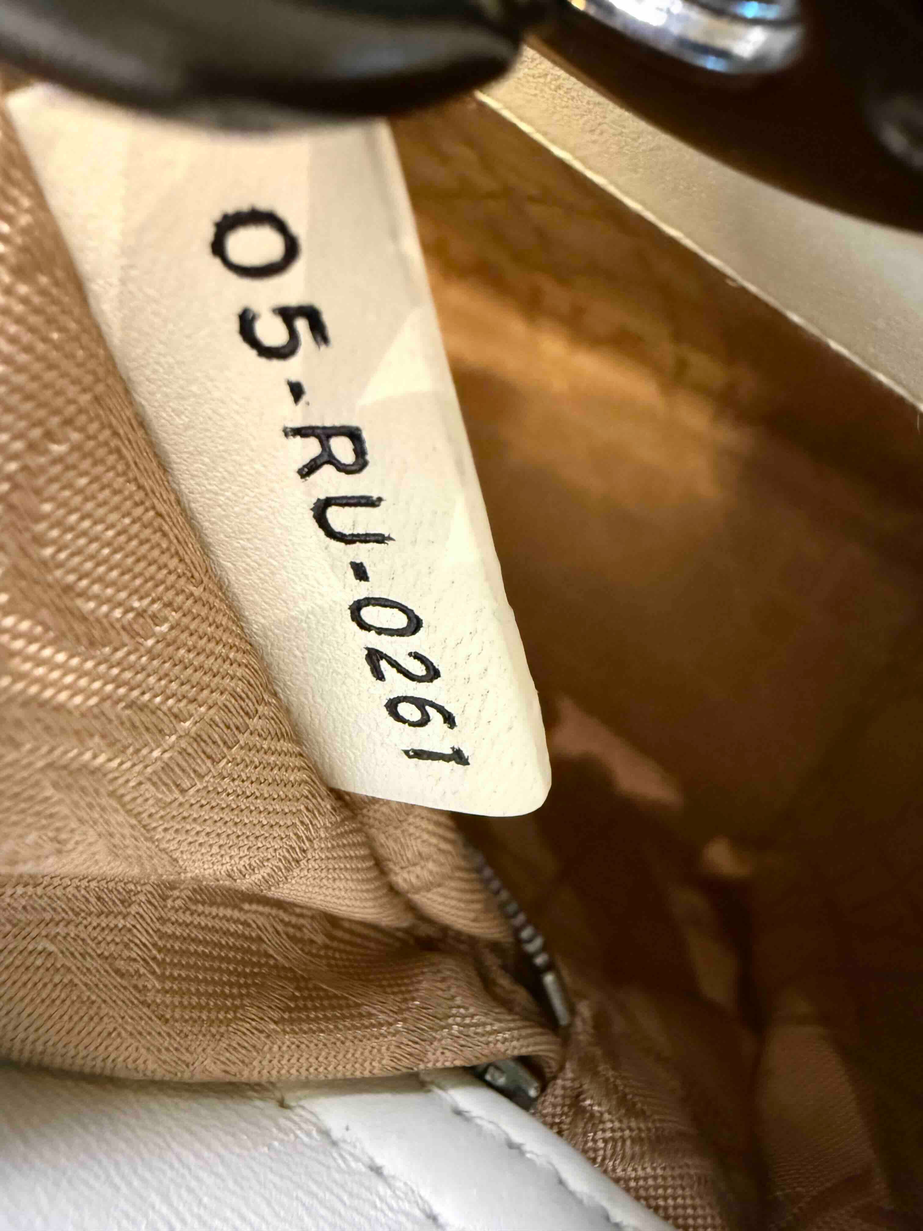 Authentic Lady Dior date code and serial number tag inside a Dior bag.