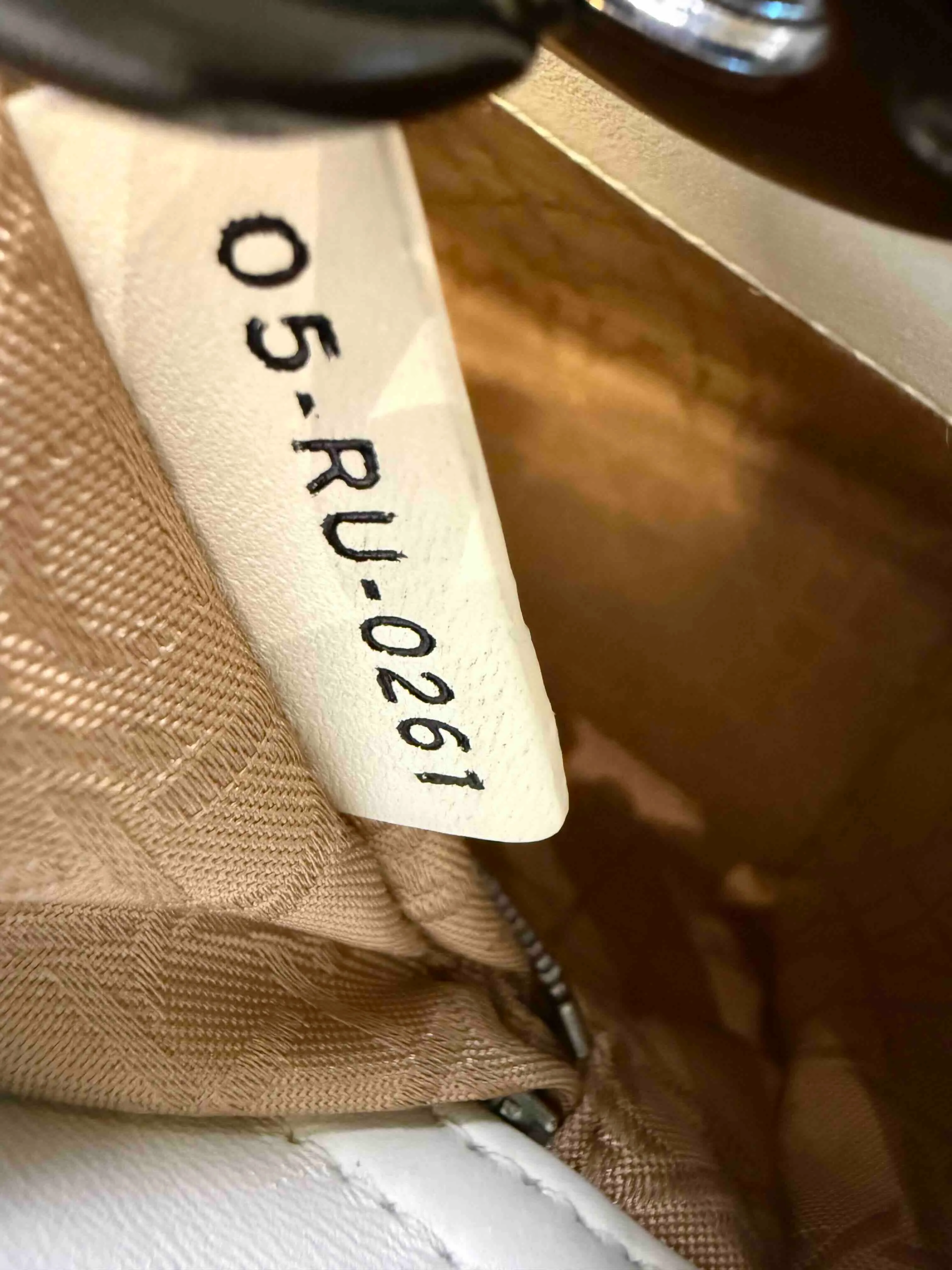 Authentic Lady Dior date code and serial number tag inside a Dior bag.