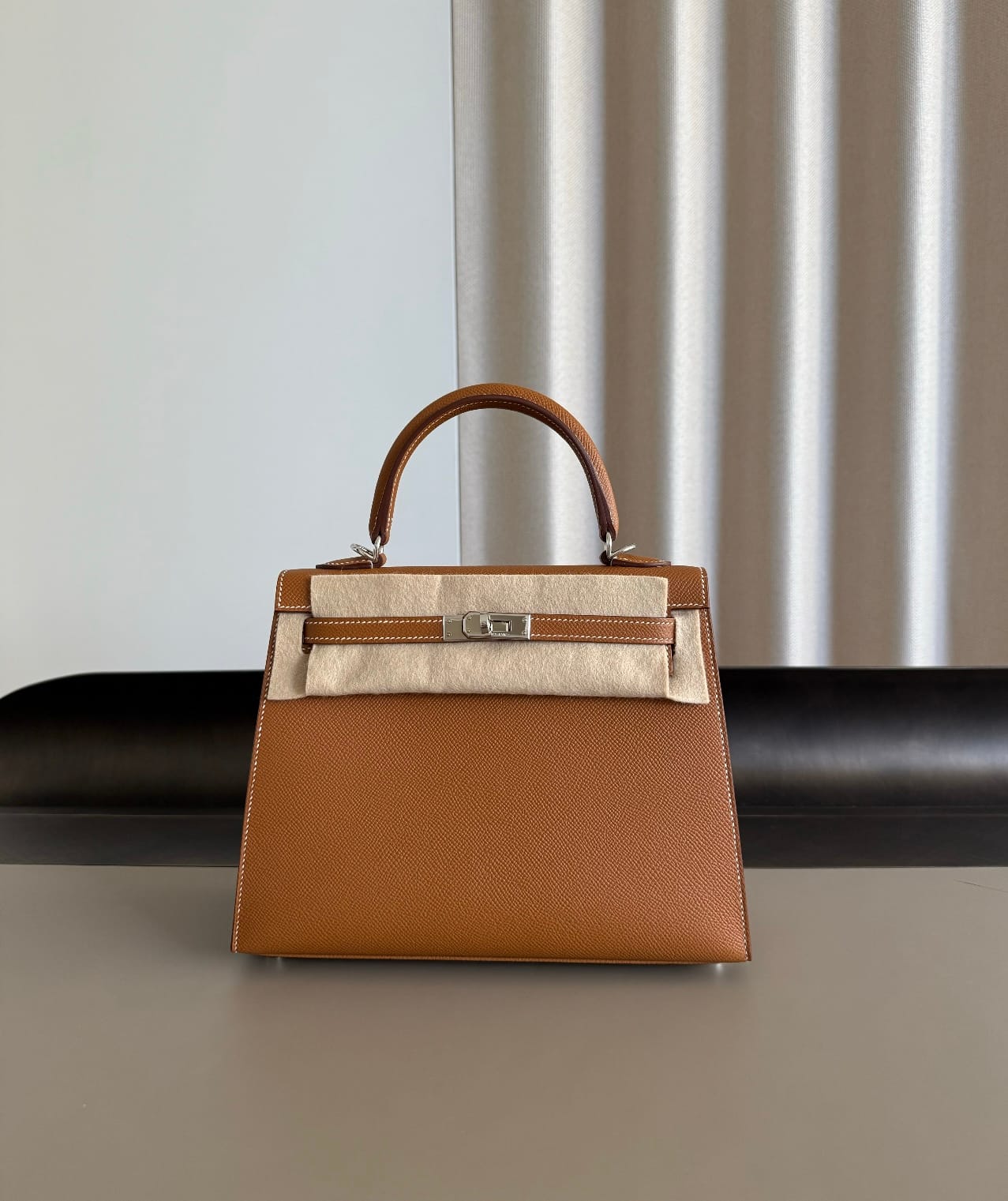 Hermès Kelly 25 bag in Gold Epsom leather showing the structured shape and embossed grain.