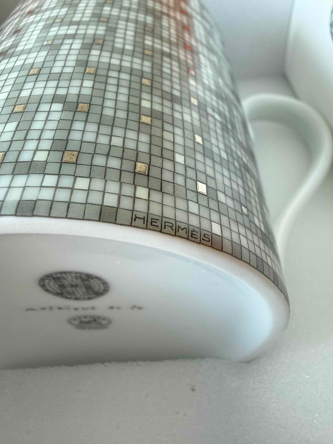 Close-up of Hermès logo and mosaic pattern on Mosaique Au 24 Platinum porcelain mug