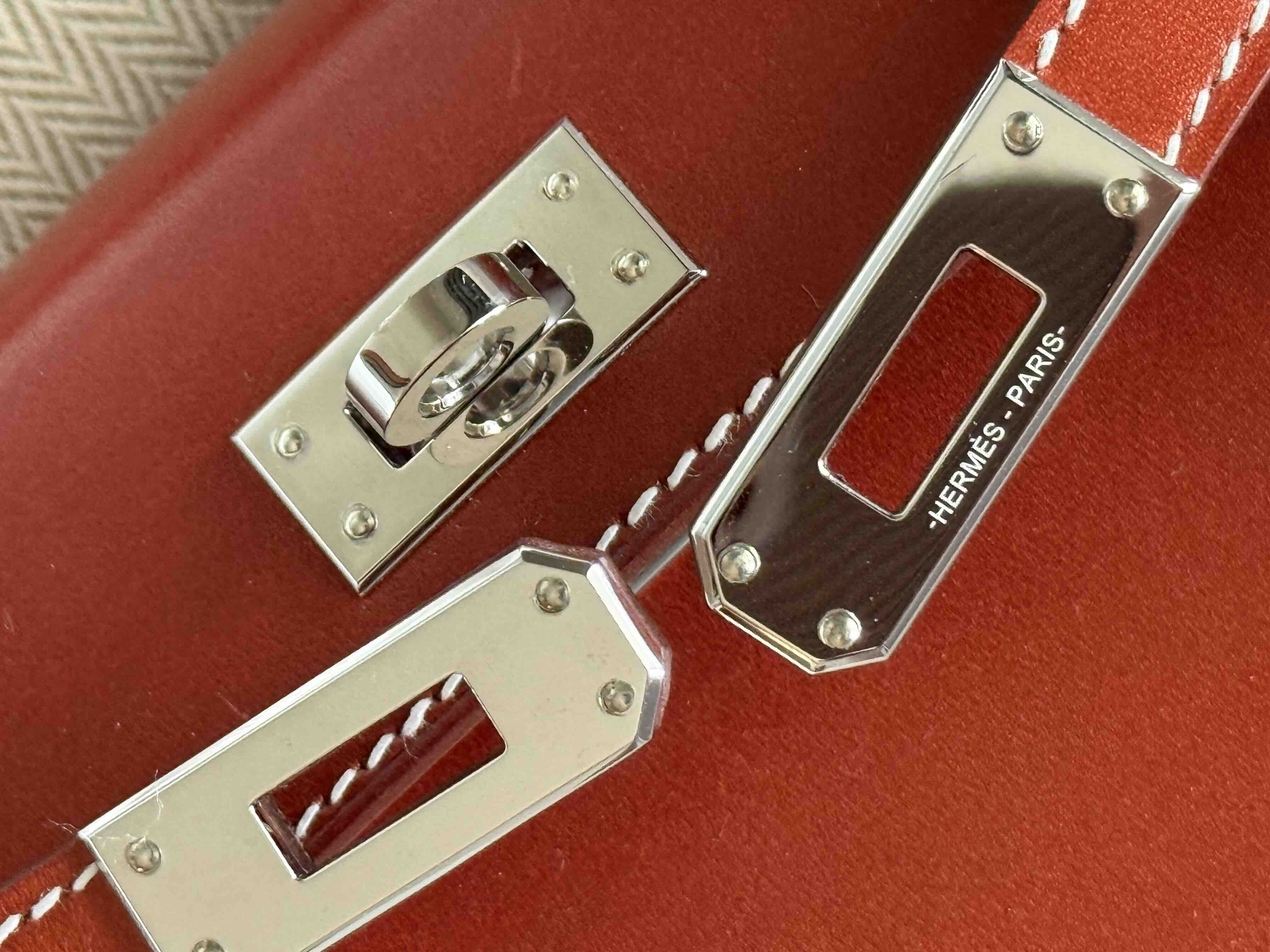 Close-up of Hermès Gold Hardware (GHW) Kelly turn-lock closure