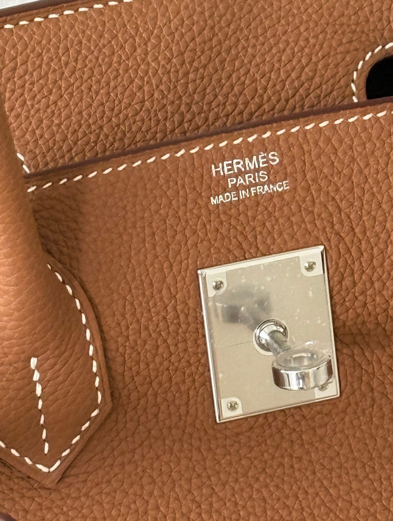 Close-up of Hermès Togo leather showing its embossed grain and rigid texture on a Birkin bag.