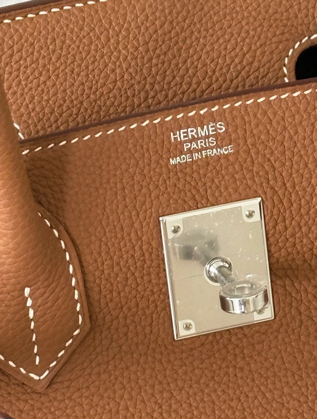 Close-up of Hermès Togo leather showing its embossed grain and rigid texture on a Birkin bag.