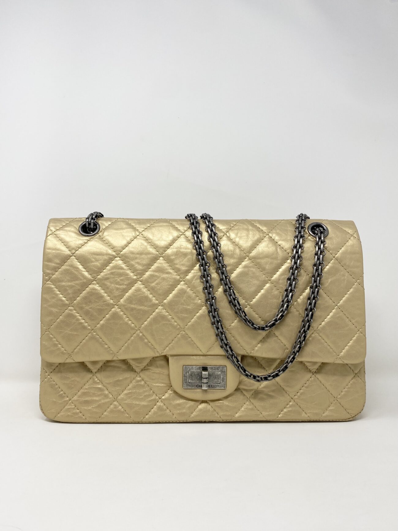 Chanel 2.55 Reissue beige aged calfskin quilted flap bag with antique silver chain hardware and Mademoiselle turn-lock, front view.