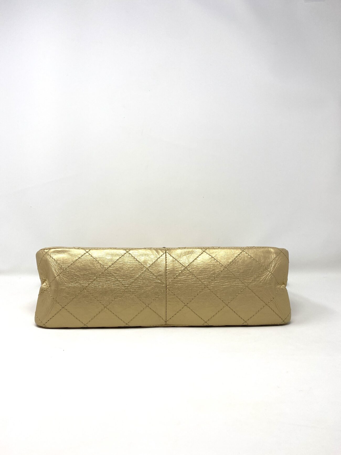 Chanel 2.55 Reissue beige aged calfskin quilted flap bag, detailed bottom view showing diamond stitching and leather texture.