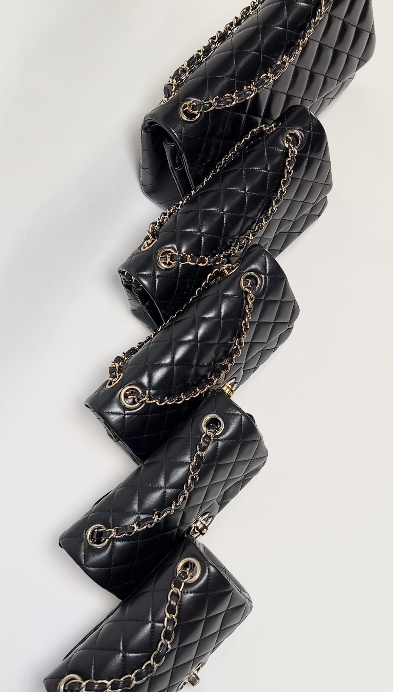 Borse Chanel Classic Flap nere in pelle matelassé con catene dorate, confronto visivo tra diverse dimensioni.