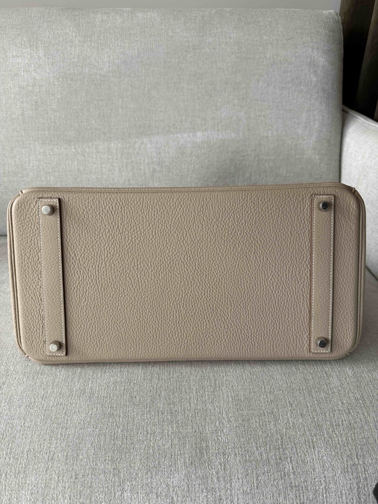 Hermès Birkin 40 Argile in Clémence leather, bottom view showing leather texture, reinforced base and four protective metal feet.